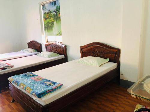 two twin beds in a room with a window at Bach Dai Dung Hotel in Ha Tinh