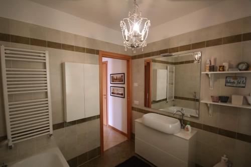 een badkamer met een wastafel, een spiegel en een kroonluchter bij Deluxe Padova Apartment in Rubano