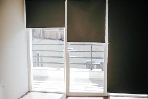 an open glass door with a view of a balcony at White & Wood in Bitola