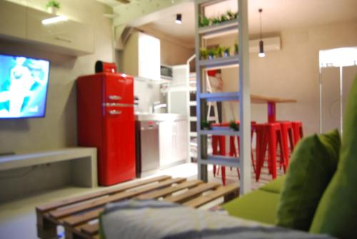 ein Wohnzimmer mit einem Sofa und einem TV sowie eine Küche in der Unterkunft Apartamento NAO MALASAÑA - GRAN VIA in Madrid