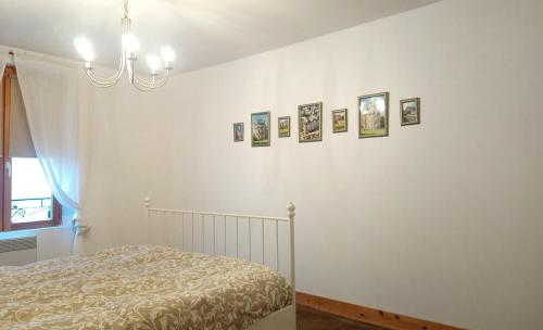 a bedroom with a bed and pictures on the wall at Charmante Maison dans petite citée de caractère 13km du ZOO in Luché-Pringé