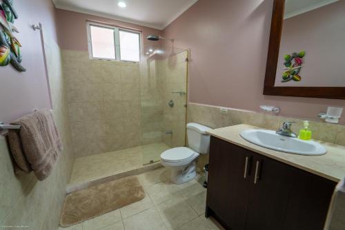 a bathroom with a shower and a toilet and a sink at The Palms Oceanfront Condo 604 in Jacó
