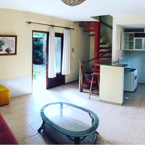 a living room with a glass table and a staircase at Pousada Corais do Sul in Pipa