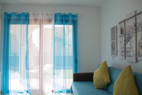 uma sala de estar com um sofá azul e uma janela em Cozy Apartment with Garden em Palm-mar