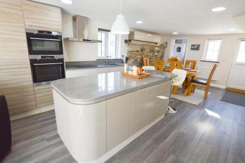 a kitchen with a large white island in a room at Sunnyside Barn in Truro