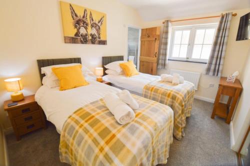 a bedroom with two beds and a window at Sunnyside Barn in Truro