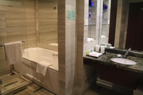 a bathroom with a tub and a sink and a shower at Jianguo Hotel Xi'an in Xi'an