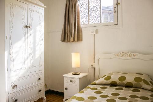 a bedroom with a bed and a dresser and a window at Hostal Providencia in Santiago