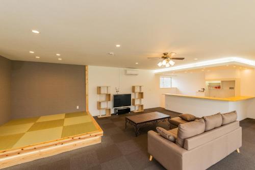 a living room with a couch and a table at Tancha Detached house / Vacation STAY 50245 in Motobu