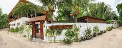a house with a palm tree on the side of it at Dive Villa Thoddoo in Thoddoo