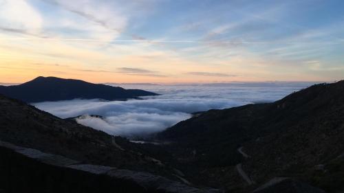 a view of a valley of clouds in the mountains at Artesano II in Navarredonda de Gredos