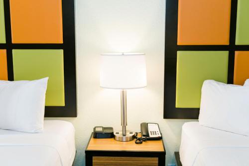 a bed room with a lamp and a phone on a table at The Flagler Inn - Saint Augustine in Saint Augustine