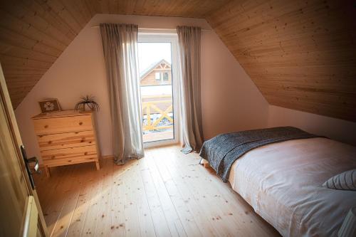 a bedroom with a bed and a large window at Wilk i Owca in Istebna