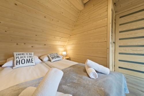 a bedroom with a bed in a wooden cabin at Domki GliczarowSKI z Jacuzzi & Sauna in Zakopane
