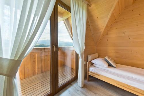a small room with a bed and a window at Domki GliczarowSKI z Jacuzzi & Sauna in Zakopane