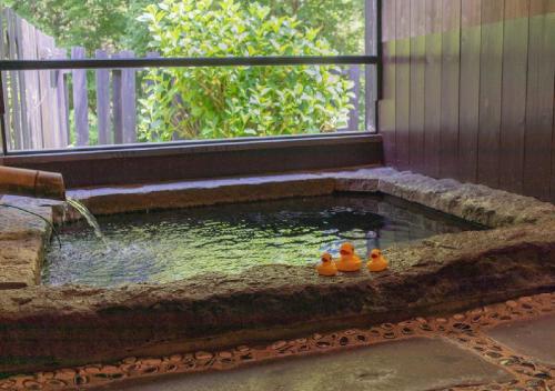 trois canards en caoutchouc assis dans un bassin d’eau dans l'établissement Kusu-gun - Hotel / Vacation STAY 51013, à Kokonoe