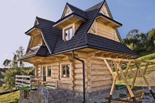 a house with a roof on top of it at Domki GliczarowSKI z Jacuzzi & Sauna in Zakopane