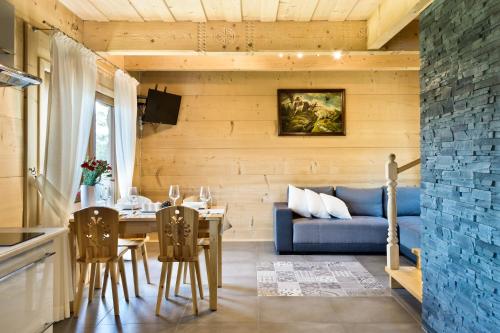 a living room with a blue couch and a table at Domki GliczarowSKI z Jacuzzi & Sauna in Zakopane