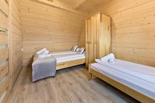 a log cabin with two beds in a room at Domki GliczarowSKI z Jacuzzi & Sauna in Zakopane