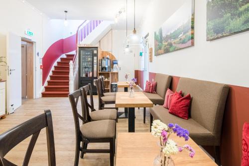 a restaurant with tables and chairs and a staircase at Schäfers Hotel, Self-Check-in, Cafe und Bäcker am Hotel in Vechta