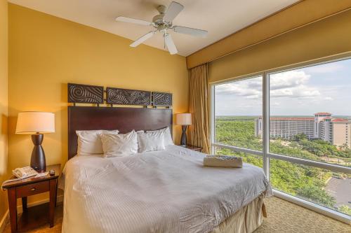 a bedroom with a bed and a large window at Luau Condos in Destin