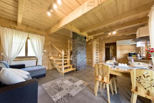 a kitchen and living room in a log cabin at Domki GliczarowSKI z Jacuzzi & Sauna in Zakopane