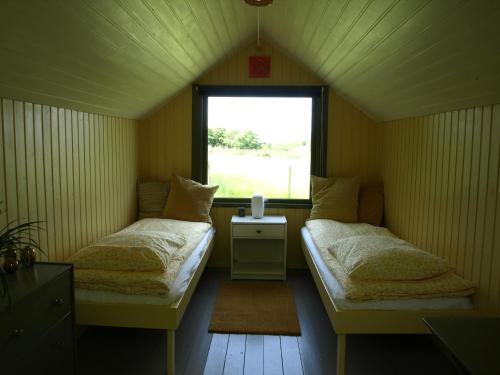 Habitación pequeña con 2 camas y ventana en Æblehaven, en Toftebjerg