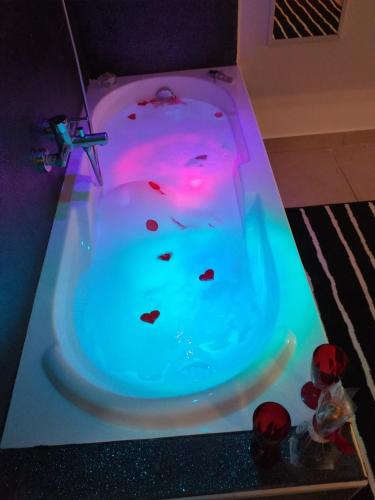 d'une baignoire avec une lumière rose et bleue. dans l'établissement casa del caravaggio, à Naples