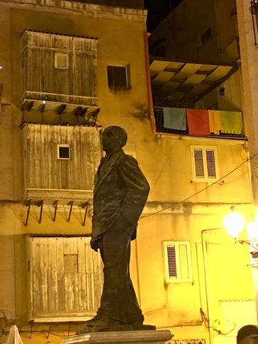 a statue of a man standing in front of a building at amurimè in Porto Empedocle