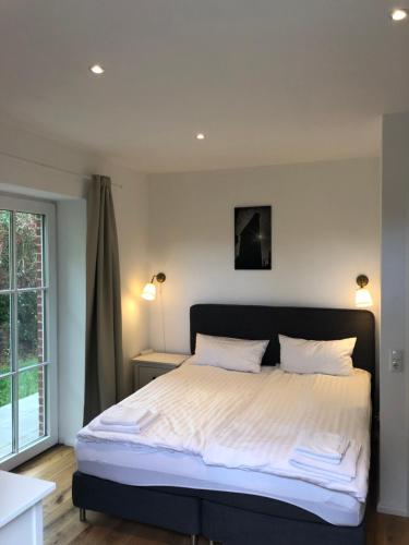 a bedroom with a large bed with white sheets at Farm-Chalet Renzow in Renzow