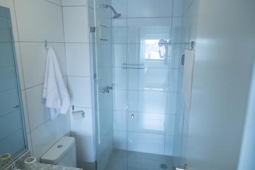 a white bathroom with a shower and a toilet at Beach Class, Ilha do Leite, Flat completo 1406 in Recife