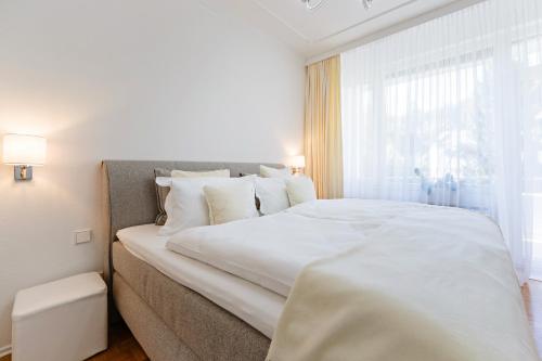 ein großes weißes Bett in einem Zimmer mit Fenster in der Unterkunft Family Apartment City Center Baden-Baden in Baden-Baden