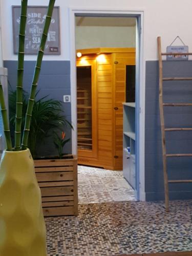 a hallway with a vase with a plant in it at Cosy Er Lann Gîte Cèdre in Val Couesnon