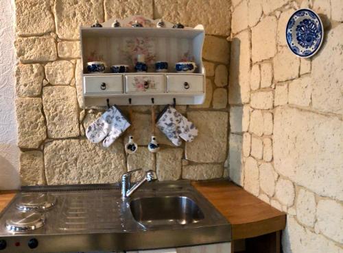 a kitchen with a sink and a stone wall at Willa na Skarpie in Oświęcim