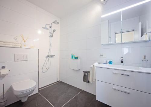 a white bathroom with a toilet and a sink at Family Apartment City Center Baden-Baden in Baden-Baden