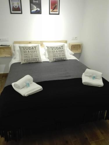 a bedroom with a large bed with towels on it at Hostal Ciempozuelos, cerca del Parque Warner y Madrid in Ciempozuelos