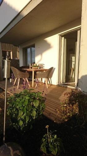 um deque de madeira com uma mesa e cadeiras numa casa em Kuhnest em Scheidegg