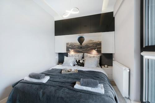1 dormitorio con 1 cama grande y armarios negros en Plac Bankowy Serviced Apartments, en Varsovia