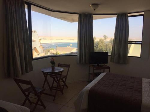 Hotel Blanco Encalada في باهيا انغليسا: غرفة نوم مع سرير وإطلالة على المحيط
