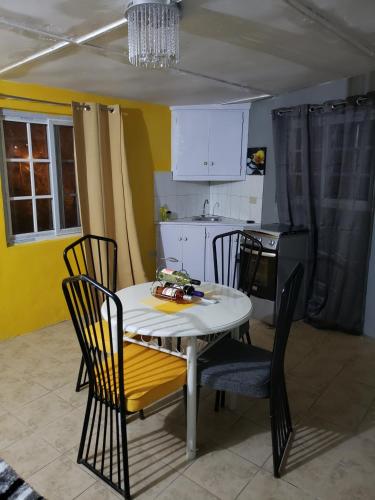 a kitchen with a white table and chairs in a kitchen at Ocean View - 1Bedroom overlooking the sea in Cane River