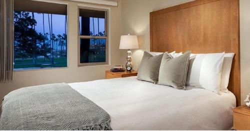 Un dormitorio con una gran cama blanca y una ventana en La Jolla Riviera Inn en San Diego
