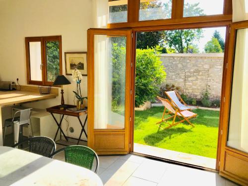 サンリスにあるMaison de Campagne by La Boîte En Plusの庭園へ通じる開放的なドア(椅子付)