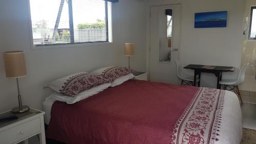 a bedroom with a bed and a desk and a window at Accommodation in Frimley in Hastings