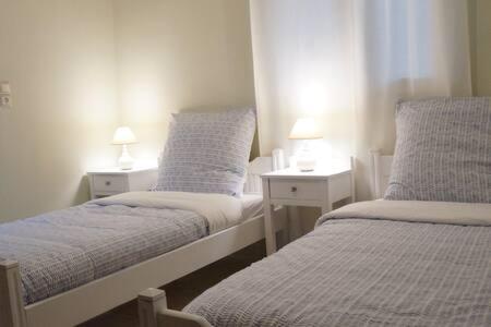 2 camas en una habitación pequeña con 2 lámparas en Michaela, en Gázion
