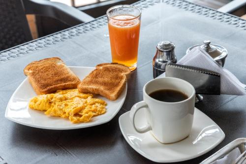a plate of eggs and toast and a cup of coffee at Hotel Olimpico in Barranquilla
