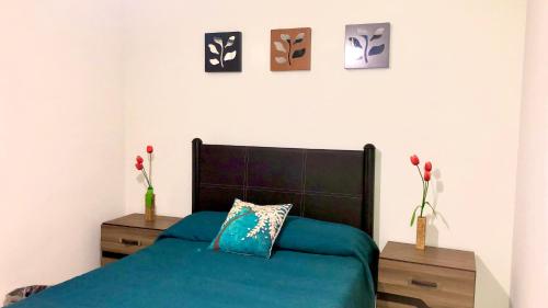 a bedroom with a blue bed and two night stands at Departamento Zona Dorada in Mazatlán