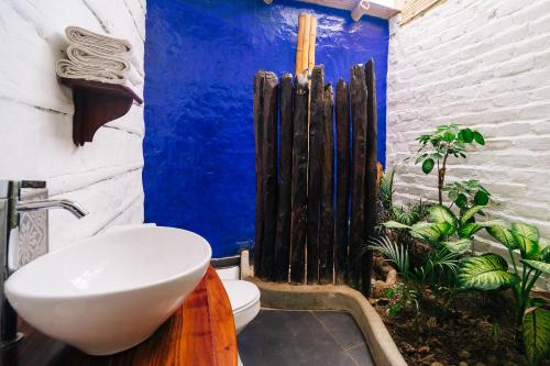 a bathroom with a sink and a toilet with a blue wall at Kimbas Bungalows Mancora in Máncora