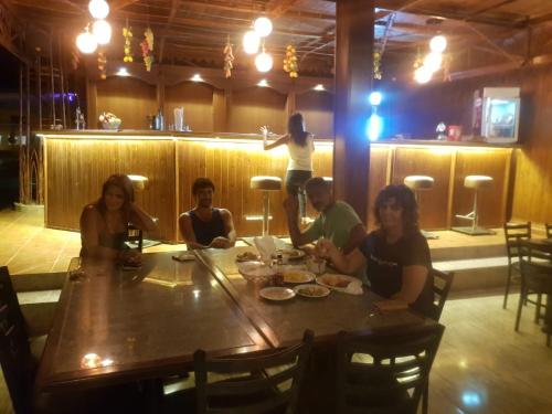 a group of people sitting around a table in a restaurant at Ciao Hotel in Nuweiba