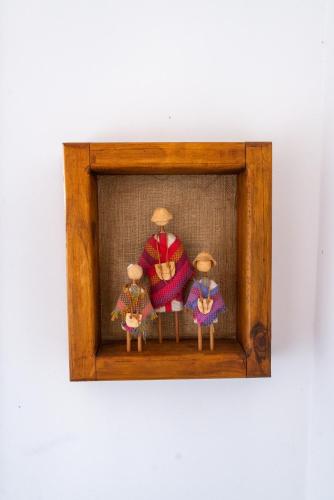 a picture of three dolls in a wooden frame at B&B HMüller in Pucón