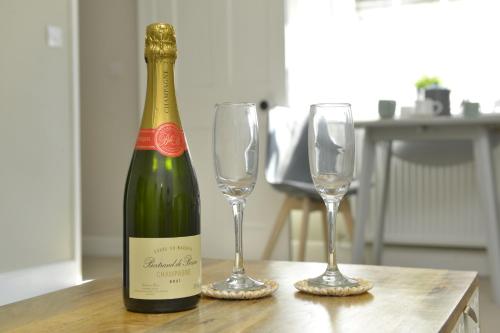 a bottle of wine and two glasses on a table at Old Green Chambers spacious town centre apartment with free parking! in St. Ives